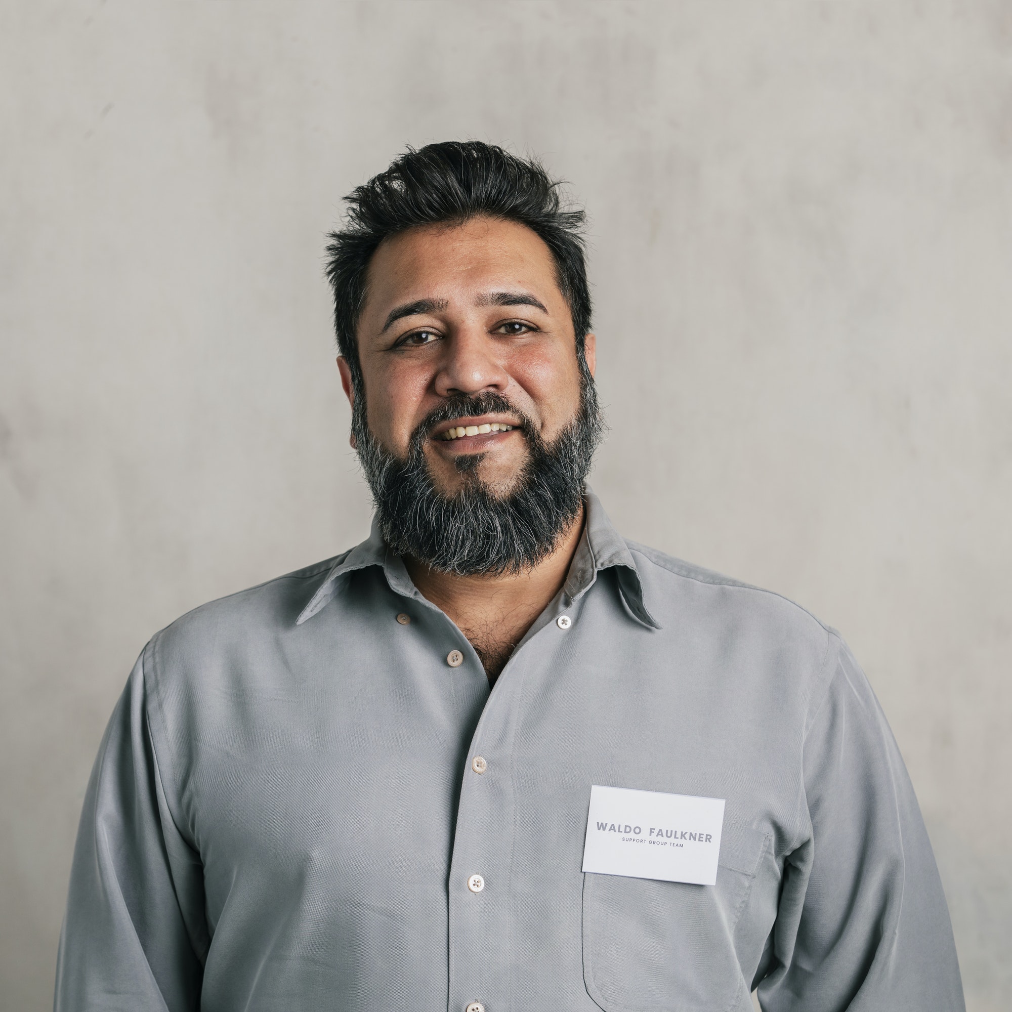 happy indian salesman wearing a name tag